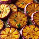 Roasted Japanese sweet potatoes in slices on a baking sheet